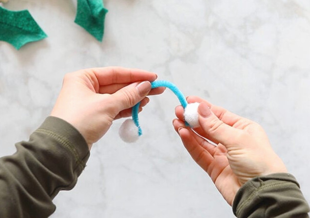 Gluing pom poms onto pipe cleaner