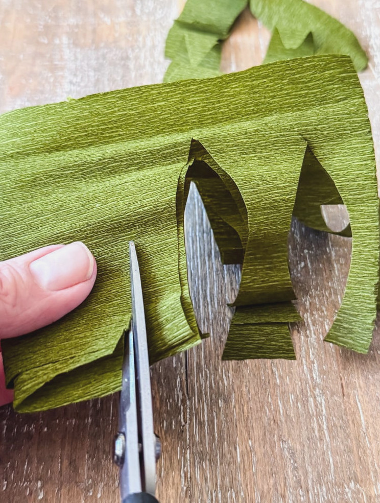 cutting leaf shapes from green crepe paper