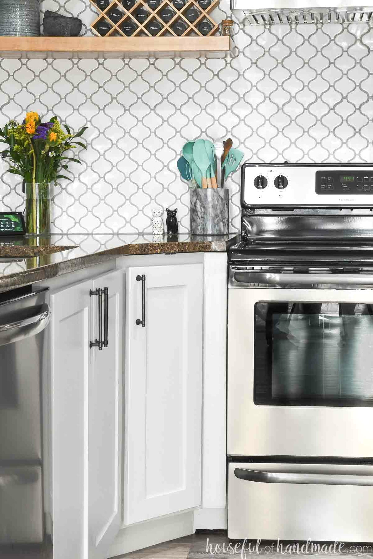 Diagonal corner base cabinet in a kitchen next to a stove.