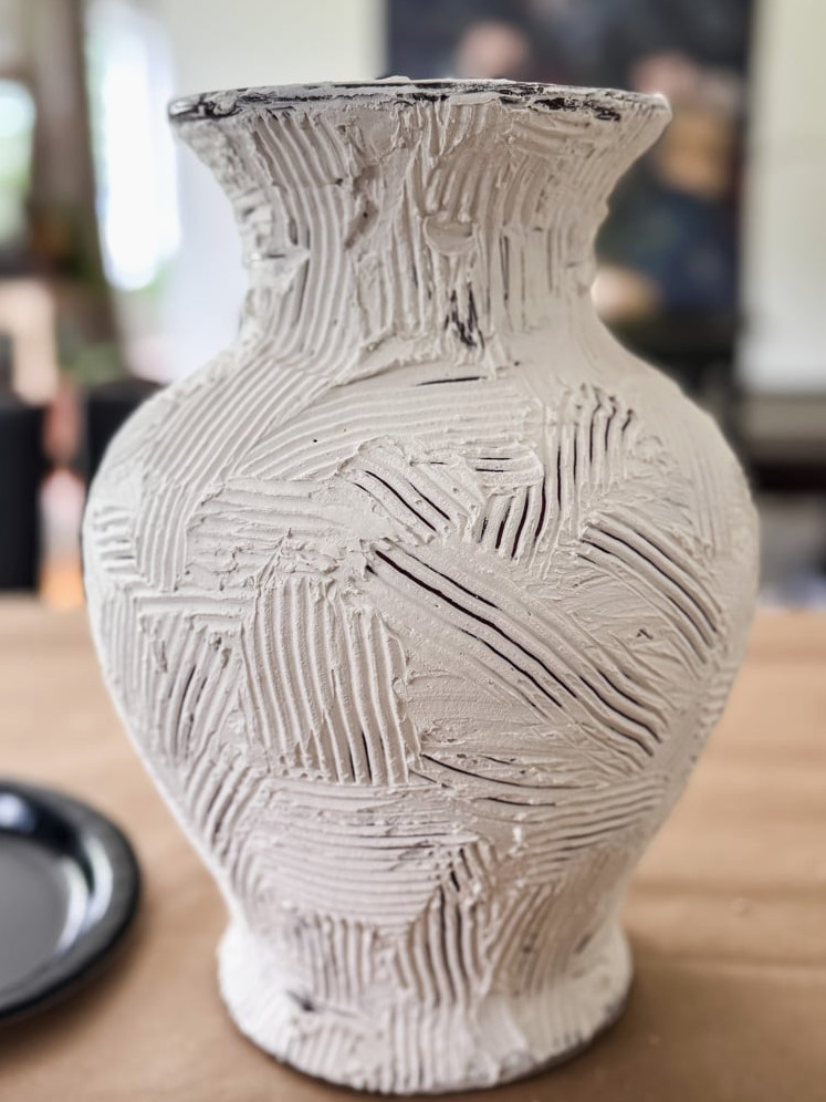 a vase covered in joint compound that has been textured with a comb like tool