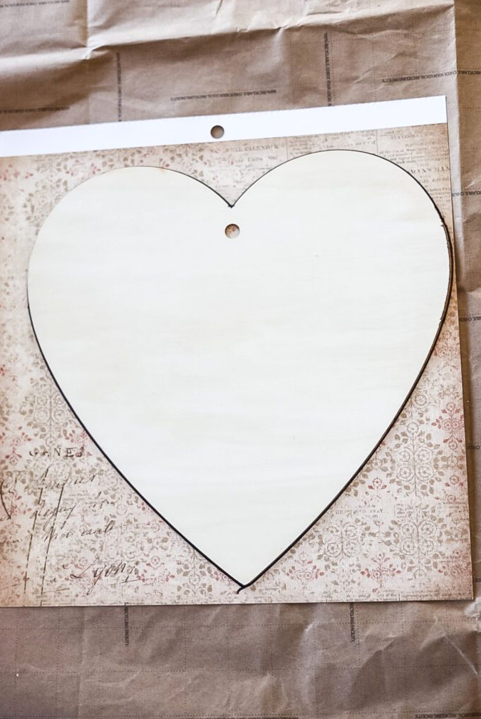 making a heart craft with a wooden heart and scrapbook paper