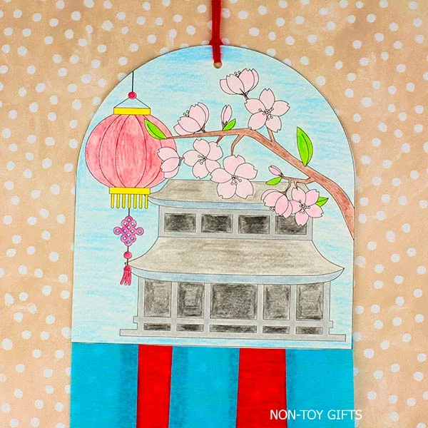 Lunar New Year printable decoration craft for kids with a hand-colored pagoda, lantern, and festive hanging streamers.
