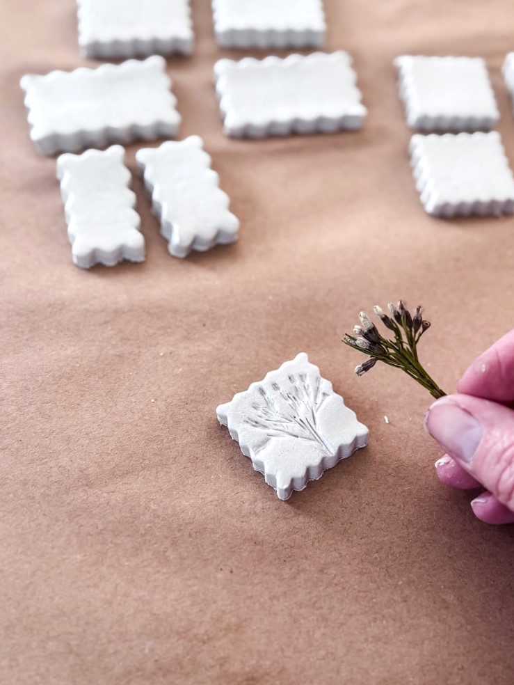 removing a small flower from the clay