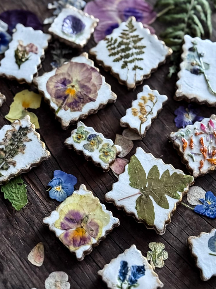 pressed flower magnets styled on top of a bed of pressed flowers
