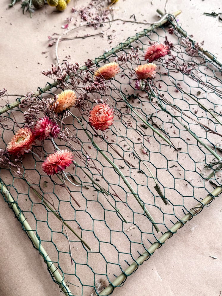 dried blossoms arranged on a frame