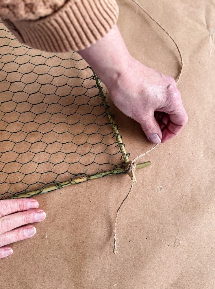 tying jute twine to a chicken wire frame