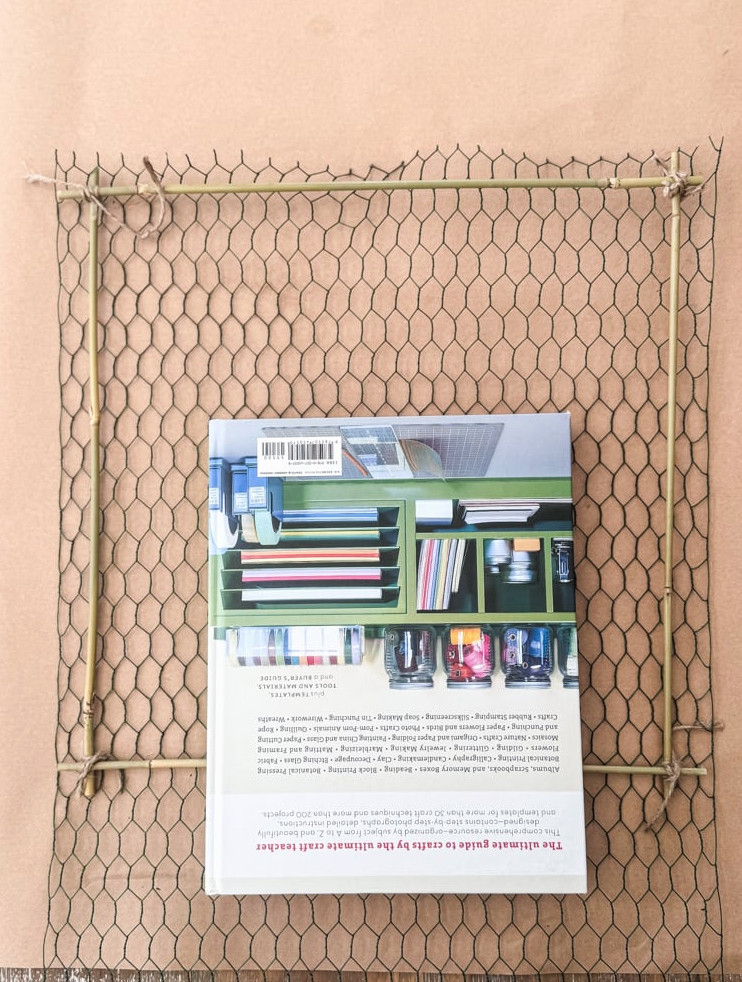 chicken wire frame being held in place by book