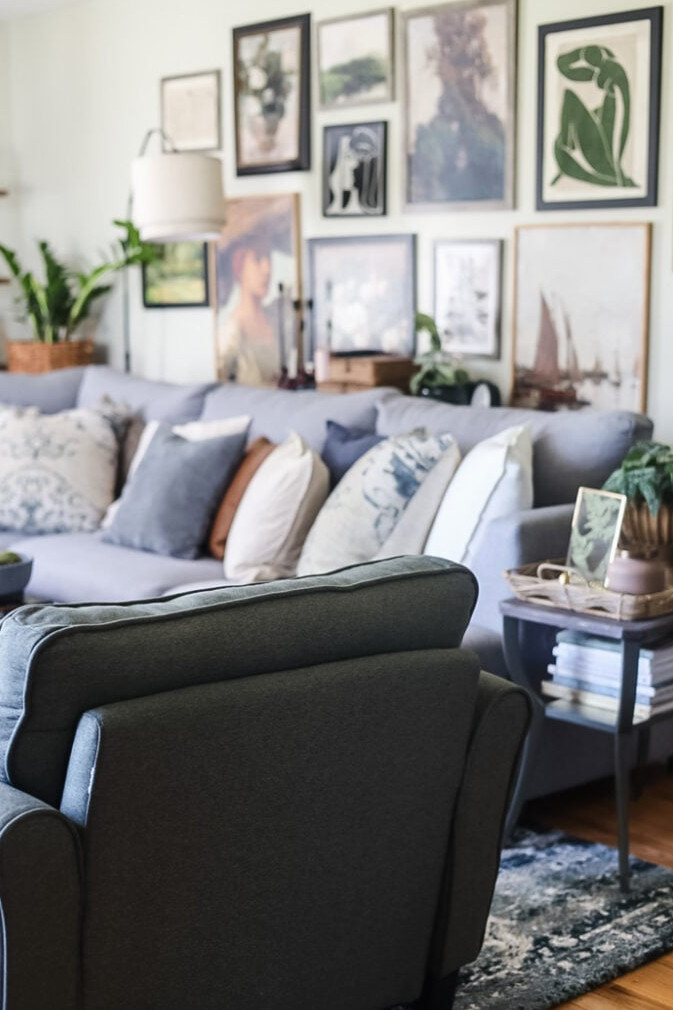 back view of a green chair looking into a living room with large gallery wall