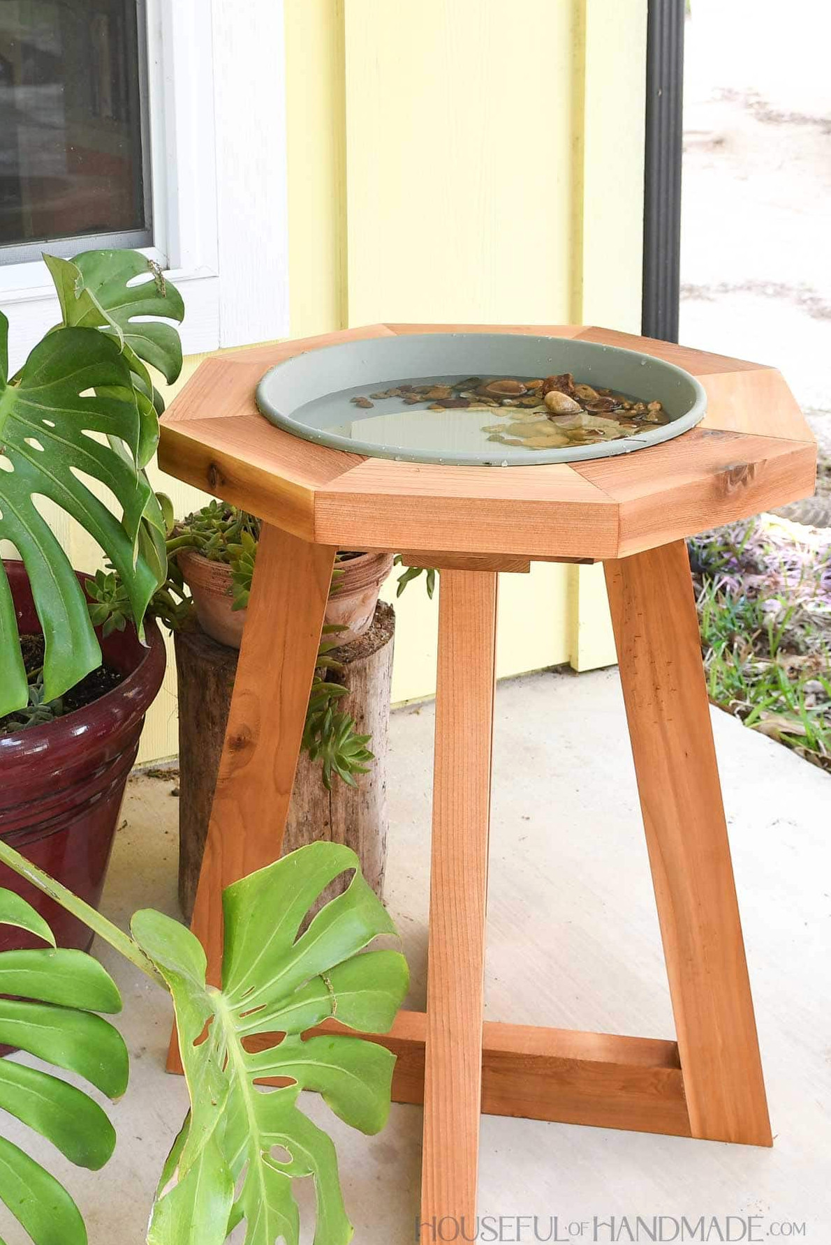 Plant saucer inside a diy birdbath stand.