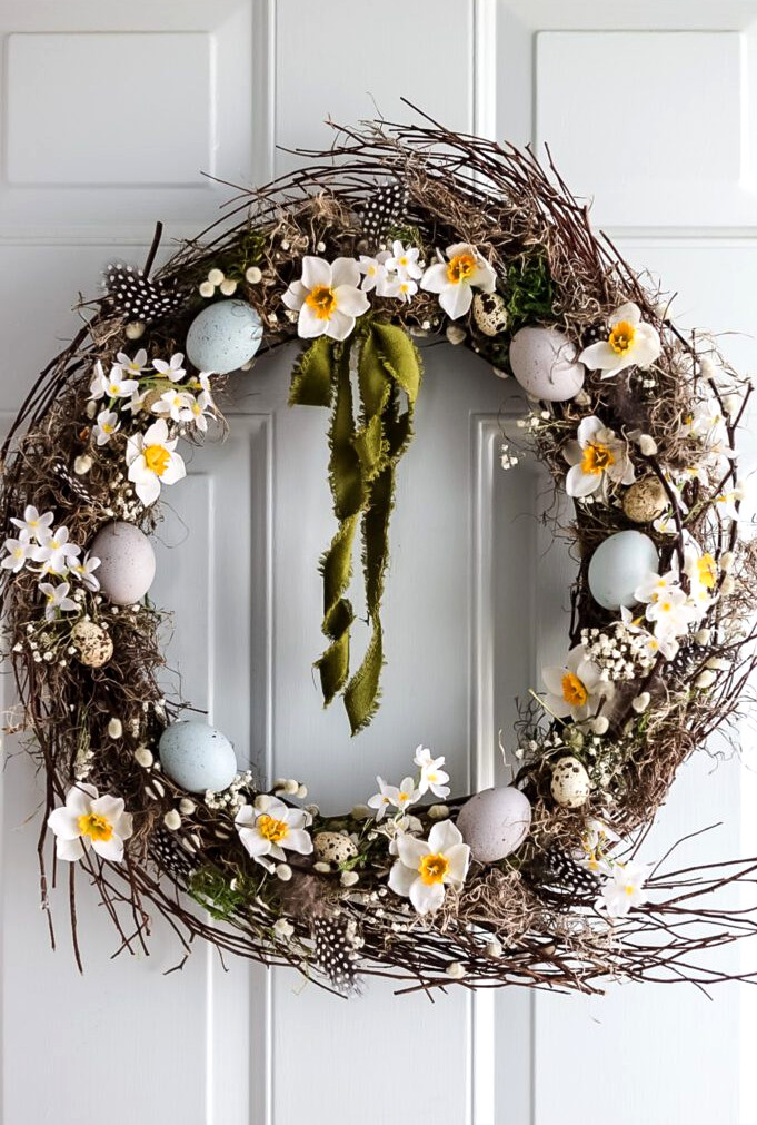 pretty spring wreath with flowers and eggs on front door