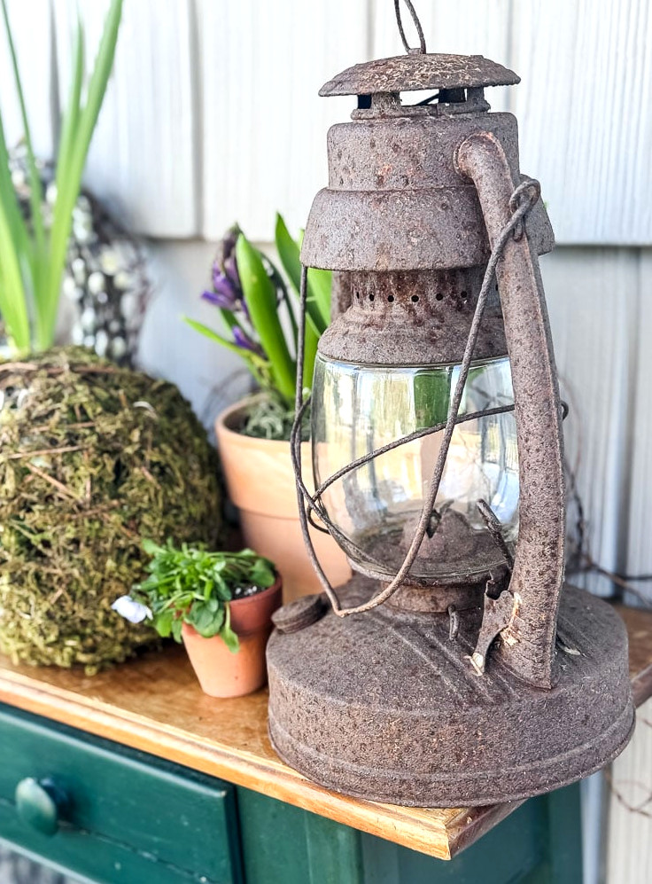 weathered lantern resting on a spring porch table