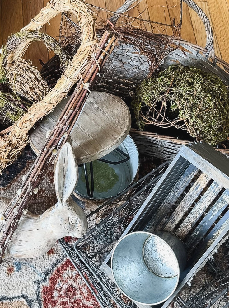 a pile of things to decorate a porch like baskets, statues, and pots