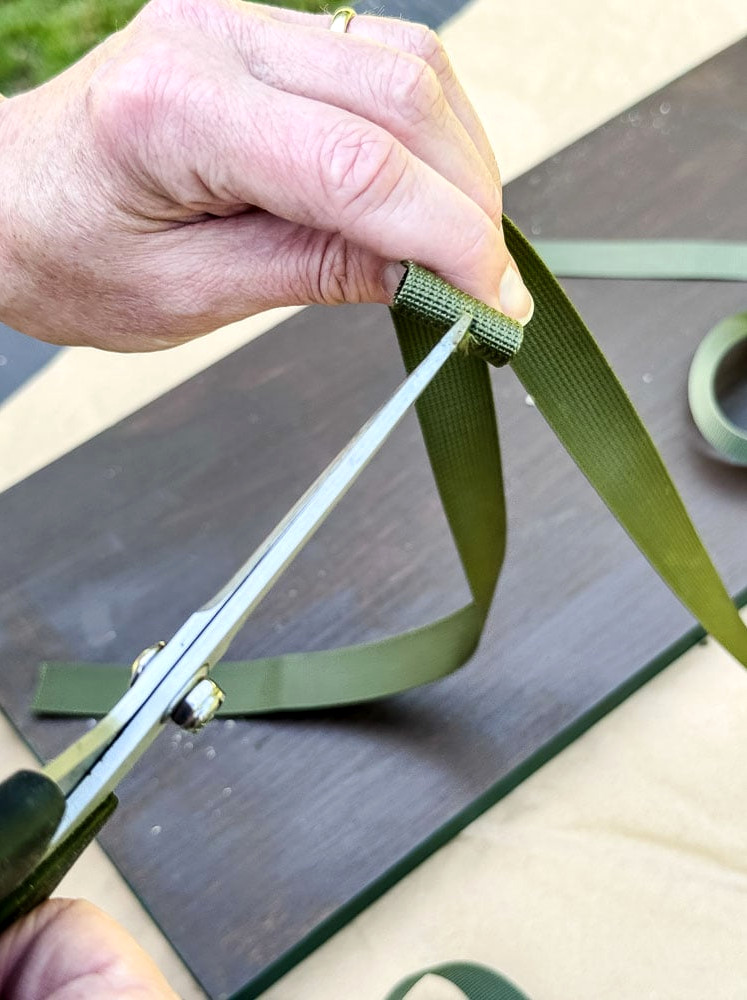 cutting a slit in a green nylon strap