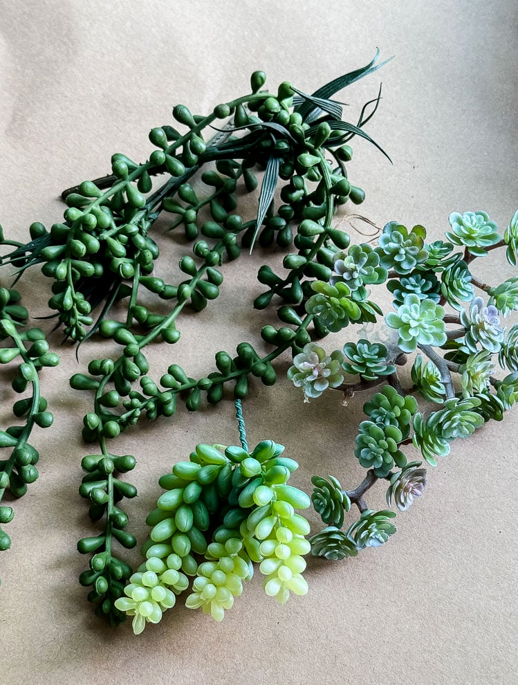 a pile of artificial succulents on brown paper